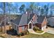 Angle view of the home showing brick and vinyl siding, roof, manicured lawn, and mature landscaping at 525 James Lee Dr, Suwanee, GA 30024