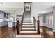 The staircase with dark wood and white trim leads to an open concept kitchen with a center island at 525 James Lee Dr, Suwanee, GA 30024
