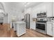Modern kitchen features stainless steel appliances, white cabinetry, and a wine rack island at 5300 Peachtree Rd # 1212, Atlanta, GA 30341