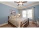 Bright bedroom with a wooden bed frame, blue accent wall and an abundance of natural light at 161 Dorys Way, Dallas, GA 30157