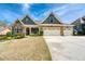 Charming two-story home with stone accents, three-car garage, and landscaped front yard under a blue sky at 161 Dorys Way, Dallas, GA 30157
