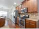 Modern kitchen with stainless steel appliances, granite countertops and beautiful wood flooring at 161 Dorys Way, Dallas, GA 30157
