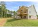 A spacious backyard with a two-story deck, green lawn, and views of the surrounding trees and blue sky at 210 Pinewood Dr, Covington, GA 30014