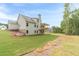 A backyard with green lawn, a two-story house with a covered deck, and a natural landscape in the background at 210 Pinewood Dr, Covington, GA 30014