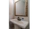 Bathroom with a pedestal sink, large mirror, and light fixtures at 210 Pinewood Dr, Covington, GA 30014
