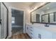 Bathroom featuring a double sink vanity, shower, and wood-style flooring at 210 Pinewood Dr, Covington, GA 30014