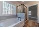 Bathroom with tub, shower, wood-style flooring, and large window at 210 Pinewood Dr, Covington, GA 30014