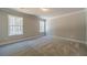 A carpeted bedroom features neutral walls, trim, and two windows at 210 Pinewood Dr, Covington, GA 30014