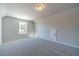 A carpeted bonus room features neutral walls and a window at 210 Pinewood Dr, Covington, GA 30014
