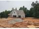 New construction home with a front porch and 2-car garage nestled amongst lush trees at 210 Pinewood Dr, Covington, GA 30014