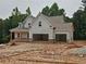 Two-story new construction home with a two-car garage and inviting front porch ready for landscaping at 210 Pinewood Dr, Covington, GA 30014