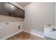 Laundry room with dark cabinets, sink, wood-style floors, and utility hookups at 210 Pinewood Dr, Covington, GA 30014