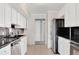Traditional kitchen with white cabinets, stainless steel appliances, and black tiled backsplash at 2390 Lawrenceville Hwy # K, Decatur, GA 30033