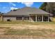 Brick home featuring a covered back porch and spacious backyard ready for outdoor entertaining at 25 Fourwood Dr, Covington, GA 30016