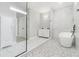 Modern bathroom with a soaking tub, frameless shower, white marble-like tile, and floating vanity at 25 Fourwood Dr, Covington, GA 30016