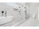 Sleek bathroom featuring a soaking tub, frameless shower, and marble tiling at 25 Fourwood Dr, Covington, GA 30016