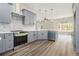 Bright kitchen features gray cabinets, modern appliances, a mosaic backsplash, and an island with barstool seating at 25 Fourwood Dr, Covington, GA 30016
