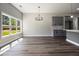 Open living area with modern chandelier, hardwood floors, and large windows overlooking a green backyard at 25 Fourwood Dr, Covington, GA 30016