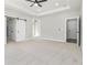 Spacious main bedroom with a ceiling fan, multiple doors, large windows, and plush carpet at 25 Fourwood Dr, Covington, GA 30016