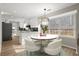 Dining area with white chairs, a round table, and views to the modern kitchen at 5427 Fieldgreen Dr, Stone Mountain, GA 30088