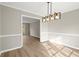 Open dining room with gray walls, white trim and baseboards, and modern chandelier at 5427 Fieldgreen Dr, Stone Mountain, GA 30088