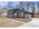 Charming two-story home with dark siding, wood shutters, and mature landscaping at 5427 Fieldgreen Dr, Stone Mountain, GA 30088
