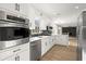 Modern kitchen with white cabinets, stainless steel appliances, black subway tile backsplash, and hardwood floors at 5427 Fieldgreen Dr, Stone Mountain, GA 30088