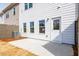 View of backyard featuring a concrete patio and a back door flanked by three windows at 125 Priestwood Ln, Acworth, GA 30102