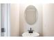 A quaint powder room features a black faucet and oval mirror at 125 Priestwood Ln, Acworth, GA 30102