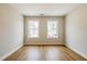 Well-lit room with hardwood floors, neutral walls, and two large windows with neighborhood views at 125 Priestwood Ln, Acworth, GA 30102