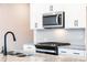 Modern kitchen design with white cabinets, granite countertops, stainless steel microwave, and black sink at 125 Priestwood Ln, Acworth, GA 30102
