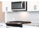 Kitchen features a stainless steel microwave, black range, granite countertops, and white herringbone tile backsplash at 125 Priestwood Ln, Acworth, GA 30102