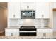 Bright kitchen features white cabinets, granite counters, stainless steel microwave, and a modern black range at 125 Priestwood Ln, Acworth, GA 30102