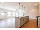 Open-concept living space with kitchen island, stainless steel appliances, pendant lighting, and wood floors at 125 Priestwood Ln, Acworth, GA 30102
