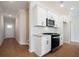 View of kitchen area features a black range, white cabinets, stainless steel microwave, and wood flooring at 125 Priestwood Ln, Acworth, GA 30102