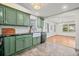 Stylish kitchen with green cabinets, dark countertops and view into the living room at 1286 Calhoun Sw Ter, Atlanta, GA 30314