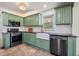 Updated kitchen featuring stainless steel appliances, green cabinetry, and a white backsplash at 1286 Calhoun Sw Ter, Atlanta, GA 30314