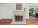 Living room showcasing a painted fireplace, hardwood floors, and an open view into the kitchen at 1286 Calhoun Sw Ter, Atlanta, GA 30314