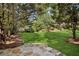 Beautiful backyard with lush green grass, mature trees, and a stone patio perfect for outdoor entertaining at 1820 Buckhead Valley Ne Ln, Atlanta, GA 30324
