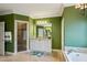 Elegant bathroom features a shower, soaking tub, granite vanity, and lovely green walls at 1820 Buckhead Valley Ne Ln, Atlanta, GA 30324
