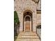 Elegant arched entryway with a stone surround, leading to a classic paneled front door at 1820 Buckhead Valley Ne Ln, Atlanta, GA 30324