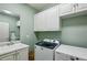 Well-equipped laundry room with built-in cabinets, sink, and modern washer and dryer units at 1820 Buckhead Valley Ne Ln, Atlanta, GA 30324