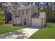Inviting two-story home with lush lawn, bay windows, and attached garage on a sunny day at 2143 Victoria Pl, Lithonia, GA 30058