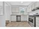 Charming kitchen features stainless appliances, granite countertops and white cabinets at 2143 Victoria Pl, Lithonia, GA 30058