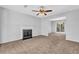 Bright living room with cozy fireplace, neutral carpet, and fan with light fixture at 2143 Victoria Pl, Lithonia, GA 30058