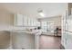 Well-lit kitchen featuring white cabinets, appliances, and a breakfast bar with wood-look flooring at 3182 Mill Springs Cir, Buford, GA 30519