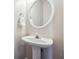 Clean half-bathroom featuring a pedestal sink and an oval mirror at 3182 Mill Springs Cir, Buford, GA 30519