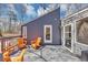 Stylish back deck featuring gray flooring, orange Adirondack chairs, and views of the home's exterior at 980 Pine Grove Pointe Dr, Roswell, GA 30075
