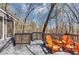 Back deck with gray flooring and orange Adirondack chairs, overlooking a scenic wooded area at 980 Pine Grove Pointe Dr, Roswell, GA 30075