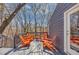 Outdoor back deck with stylish gray flooring, orange Adirondack chairs, and views of the lush, wooded landscape at 980 Pine Grove Pointe Dr, Roswell, GA 30075